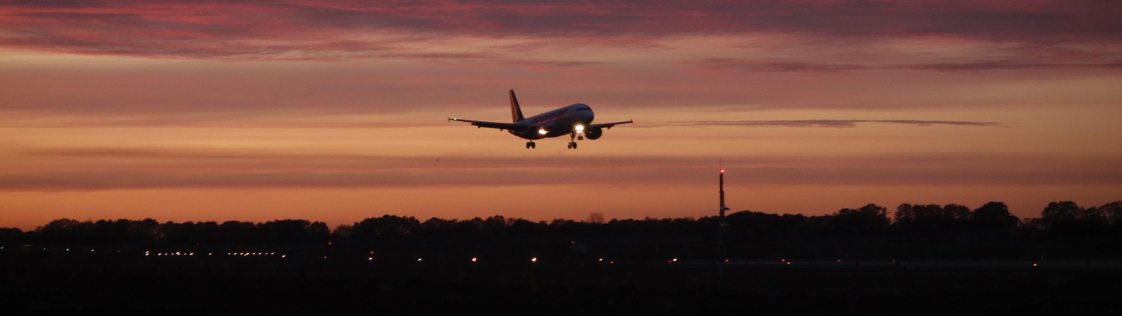 Fly Less Hero Image _ plane taking off at sunset